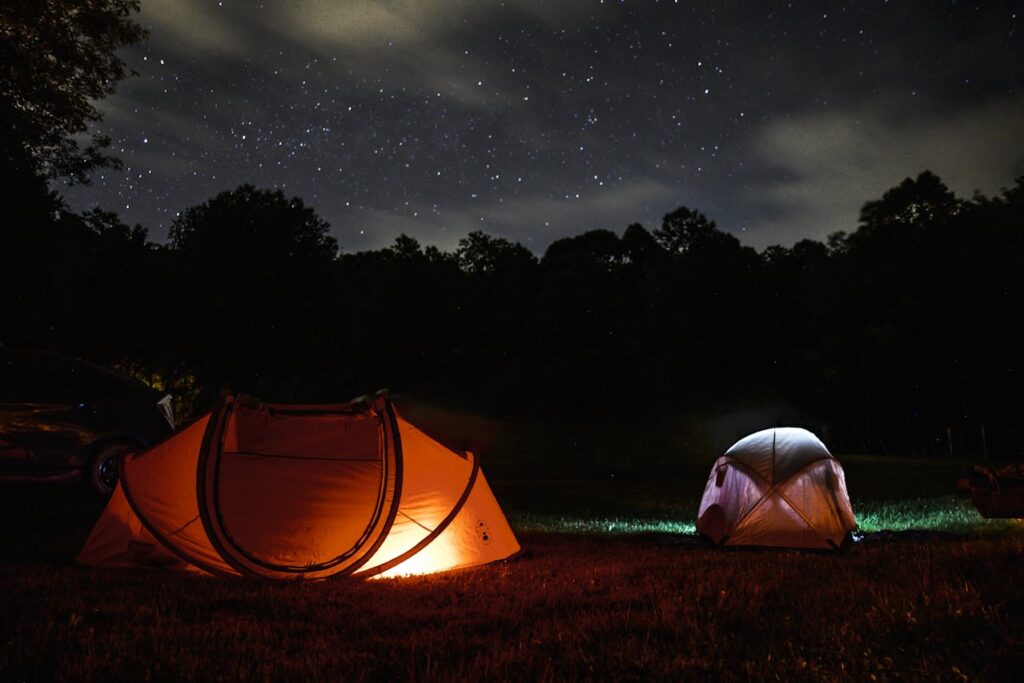 Two lighted dome tents at night